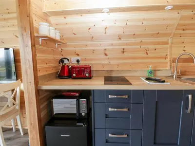 a kitchen in a tiny house with a counter and a sink at Cleugh Lodge in Lockerbie