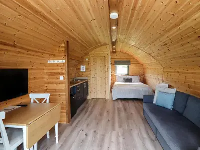 a room with a bed in a wooden cabin at Cleugh Lodge in Lockerbie