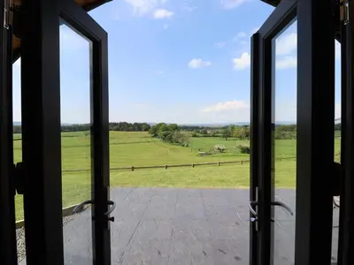 an open door with a view of a green field at Dryfe Lodge in Lockerbie