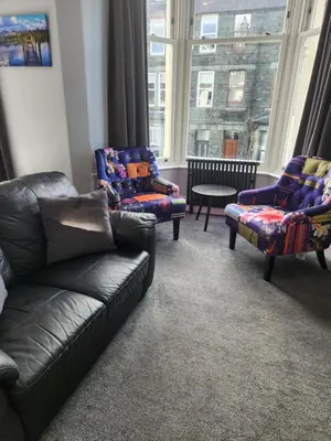 a living room with a couch and chairs and a window at Herdwick Guest House in Keswick