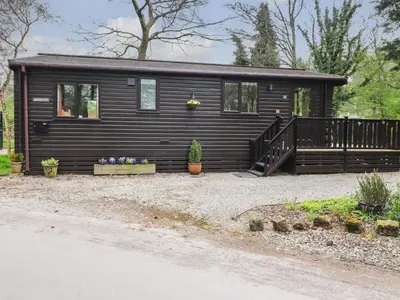 a black tiny house with a porch and a staircase at Derwent Lodge in Keswick