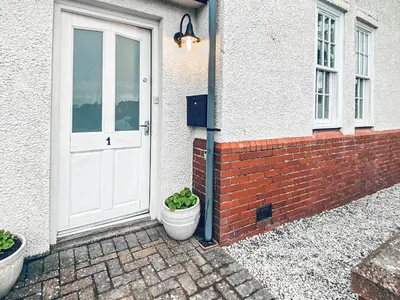 a door of a house with two potted plants next to it at The Court House - Uk43908 in Silloth