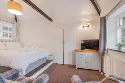 a bedroom with a bed and a flat screen tv at Cottage 5 mews Studio in Keswick