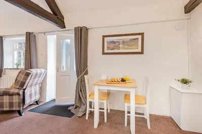 a small kitchen with a table and chairs in a room at Cottage 5 mews Studio in Keswick