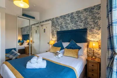 a bedroom with a large bed with towels on it at Avondale Guest House in Keswick