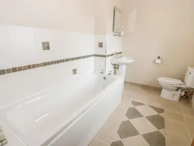 a bathroom with a tub and a toilet and a sink at Laird House in Lockerbie
