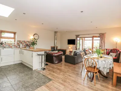 a kitchen and living room with a table and chairs at Laird House in Lockerbie