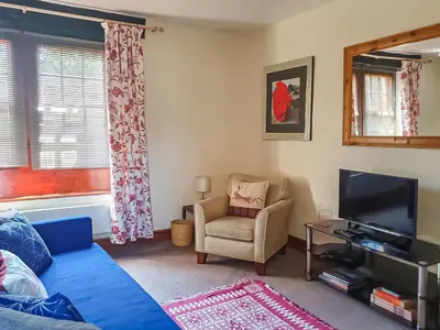 a living room with a couch and a tv and a chair at Market Place in Workington