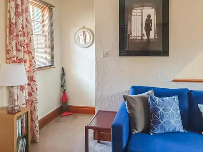 a living room with a blue couch and a clock at Market Place in Workington
