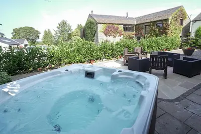 a hot tub in the backyard of a house at Brae Fell Cottage, Sebergham, Nr Caldbeck dog friendly and hot tub in Sebergham
