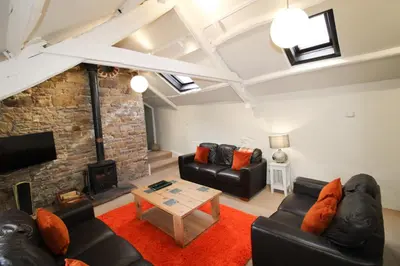 a living room with two couches and a fireplace at Brae Fell Cottage, Sebergham, Nr Caldbeck dog friendly and hot tub in Sebergham