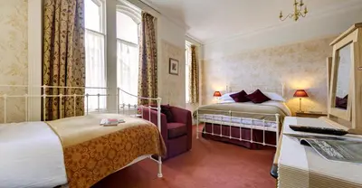 a hotel room with two beds and a desk at The Edwardene in Keswick