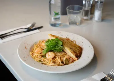 a plate of pasta with shrimp and toast on a table at The Fenwick Hotel in Kilmarnock