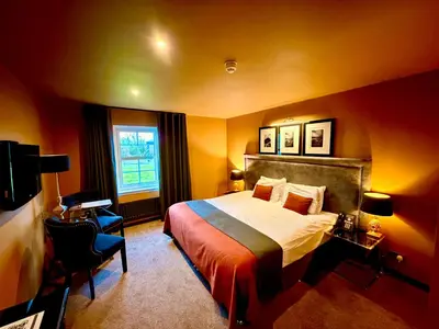 a hotel room with a bed and a window at The Fenwick Hotel in Kilmarnock