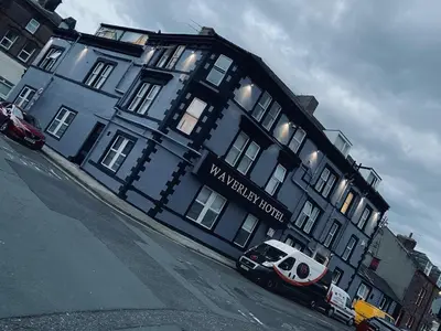 a blue building with a van parked in front of it at Waverley Hotel in Workington