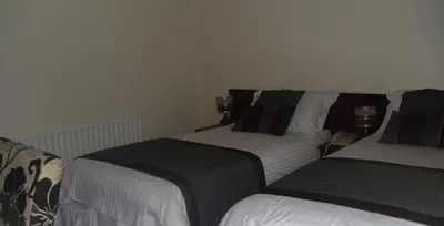 two beds sitting next to each other in a room at Waverley Hotel in Workington