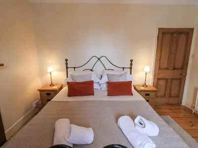 a bedroom with a large bed with towels on it at Primrose Cottage in Keswick