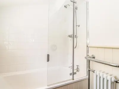 a shower with a glass door in a bathroom at Primrose Cottage in Keswick