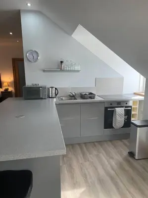 a kitchen with a stove and a counter top at Luxury Studio Loft with Car Charging Point in Frizington