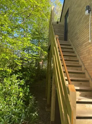 a staircase leading up to a house with trees at Luxury Studio Loft with Car Charging Point in Frizington
