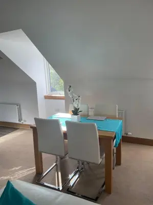 a dining room with a table and white chairs at Luxury Studio Loft with Car Charging Point in Frizington