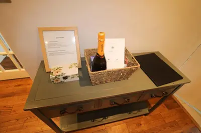 a bottle of wine on a table with a box at Calley House, Hutton remote cottage with hot tub, 10 minutes to Ullswater in Penruddock