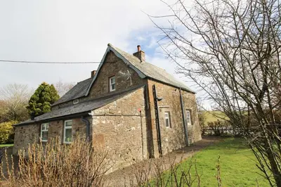 an old brick building in a green field at Calley House, Hutton remote cottage with hot tub, 10 minutes to Ullswater in Penruddock