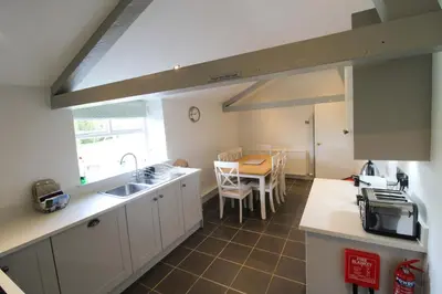 a kitchen with a sink and a table at Calley House, Hutton remote cottage with hot tub, 10 minutes to Ullswater in Penruddock
