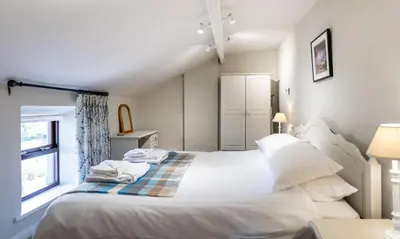 a bedroom with a large bed with white sheets and pillows at Chapel Beck, Nr Caldbeck ideally family accommodation with hot tub in Sebergham
