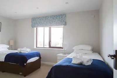 a bedroom with two beds and a window at Cloven Stone, Nr Caldbeck ideal family accommodation with hot tub in Sebergham