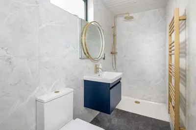 a bathroom with a toilet and a sink and a mirror at Daffodil, Penruddock Eco & dog friendly lodge with hot tub in Penruddock