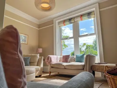 a living room with a couch and a window at High House, Southwaite in a rural setting with countryside views, garden with BBQ & hot tub in Southwaite