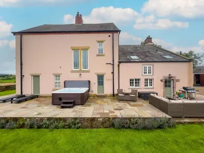 a house with a backyard with a hot tub at High House, Southwaite in a rural setting with countryside views, garden with BBQ & hot tub in Southwaite