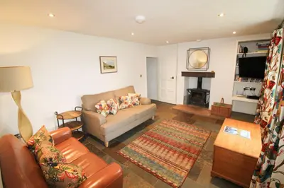 a living room with a couch and a table at Red Squirrel Cottage, Hutton luxurious cottage in a rural setting 10 minutes to Ullswater 15 minutes to Keswick in Penruddock