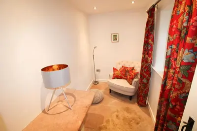 a living room with a chair and a lamp at Red Squirrel Cottage, Hutton luxurious cottage in a rural setting 10 minutes to Ullswater 15 minutes to Keswick in Penruddock