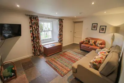 a living room with a couch and a table at Red Squirrel Cottage, Hutton luxurious cottage in a rural setting 10 minutes to Ullswater 15 minutes to Keswick in Penruddock