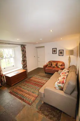 a living room with a couch and a table at Red Squirrel Cottage, Hutton luxurious cottage in a rural setting 10 minutes to Ullswater 15 minutes to Keswick in Penruddock