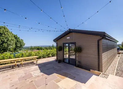 a small shed with a bench on a patio at The Farmhouse, Sebergham, spacious family or group accommodation in a rural setting close to Caldbeck in Sebergham