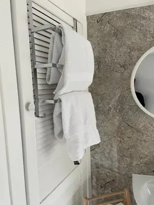 a bathroom with white towels hanging on a towel rack at Little Limetree in Moffat