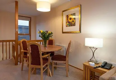 a dining room with a table with chairs and a lamp at Keswick Bridge 5,within walking distance of Keswick town centre, strictly no pets in Keswick