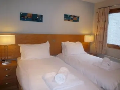 two beds in a hotel room with towels on them at Keswick Bridge 5,within walking distance of Keswick town centre, strictly no pets in Keswick