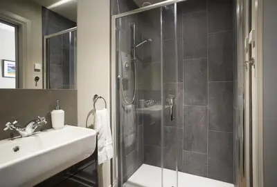a bathroom with a shower and a sink and a toilet at Netherwood Lodge in Dumfries