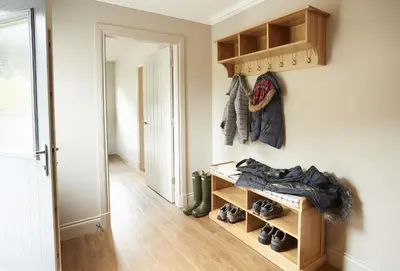 a room with a hallway with shoes on the wall at Netherwood Lodge in Dumfries