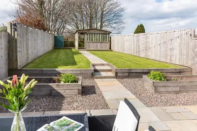 a garden with a wooden fence and a gazebo at Cottage - Sleeps 3 hot tub & pet friendly in Carlisle