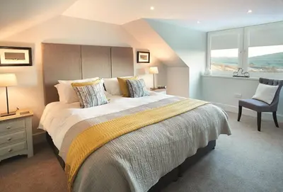 a bedroom with a large bed and a chair at Corriedow in Thornhill