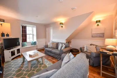 a living room with a couch and a tv at 3 bedroom townhouse right on the harbour in Isle of Whithorn