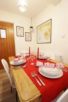 a dining room table with a red table cloth at 14 Union Street in Kirkcudbright