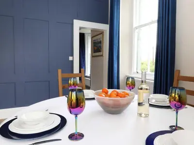 a table with a bowl of oranges and two wine glasses at Redwood Rise Apartment Keswick at The Lairbeck in Keswick