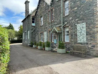 a brick building with a bench in front of it at Redwood Rise Apartment Keswick at The Lairbeck in Keswick
