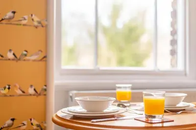 a table with two glasses of orange juice on it at Cameron Fell Apartment Keswick at The Lairbeck in Keswick